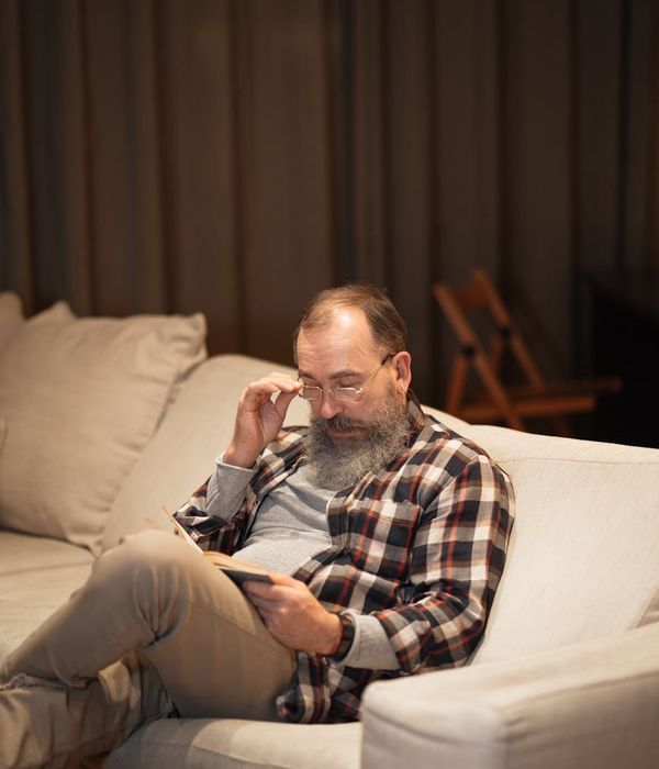 Man stretching on a yoga mat in a bright, modern apartment.